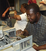 Student taking a computer apart and repairing it.